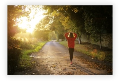 woman walking leisurely through the woods taking some light exercise